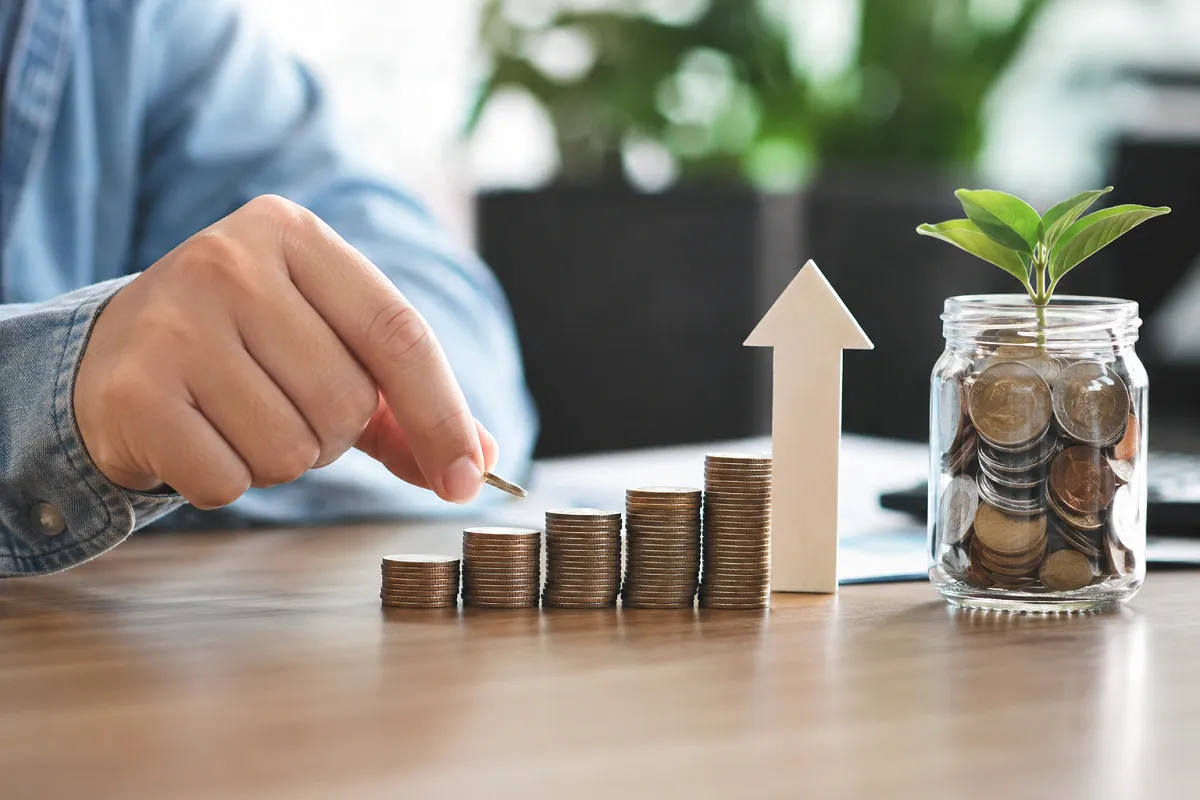 LessInvest.com investment growth with rising coin stacks and savings concept.